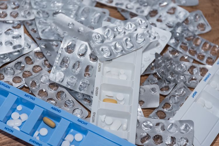 Bild eines Tisches mit vielen leeren Arzneimittelverpackungen