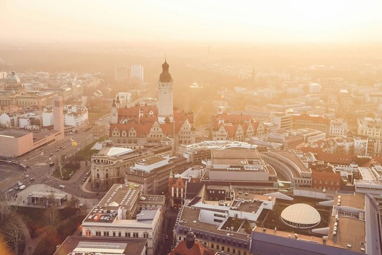 Das Bild zeigt Leipzig von oben, mit dem Neuen Rathaus im Hintergrund. 