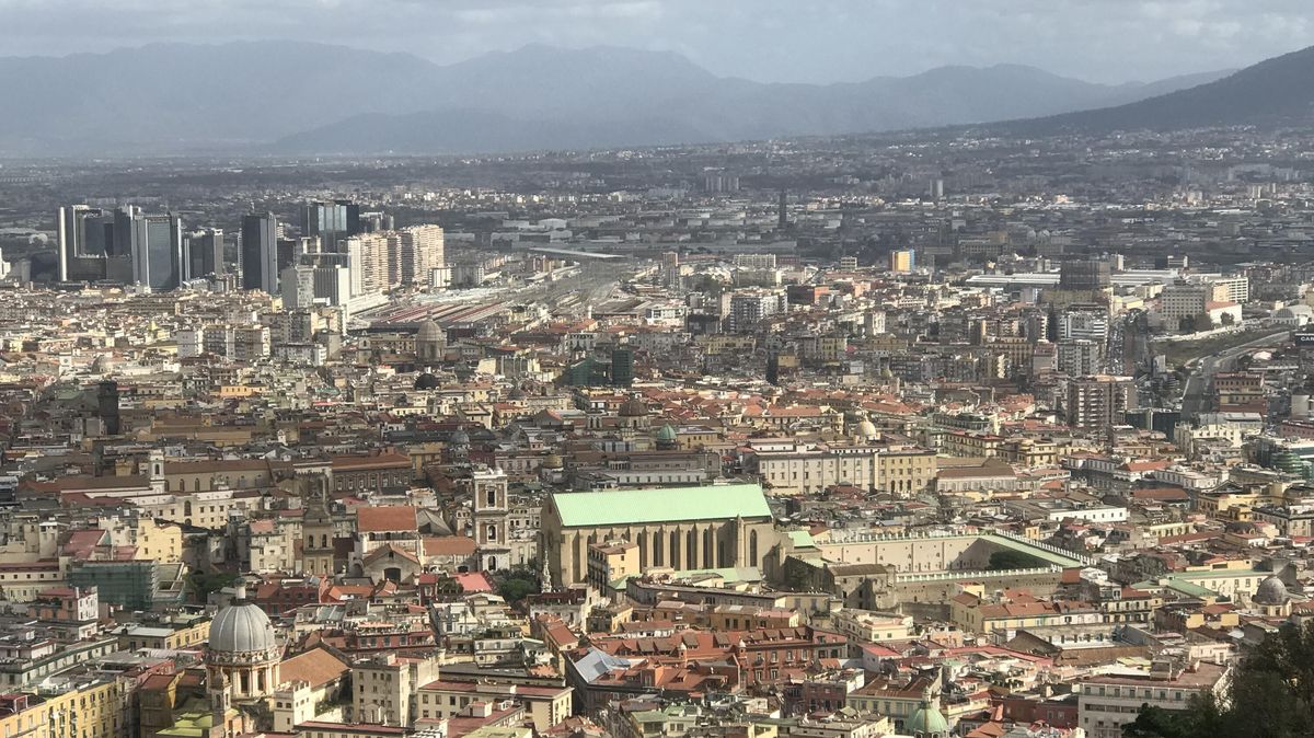 zur Vergrößerungsansicht des Bildes: Zu sehen ist ein Panorama der Stadt Neapel mit dem Vesuv im Hintergrund.
