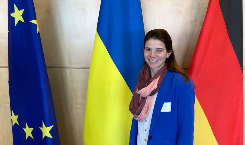 Die Politikwissenschaftlerin Prof. Dr. Solveig Richter vor den Flaggen der EU, der Ukraine und Deutschlands.