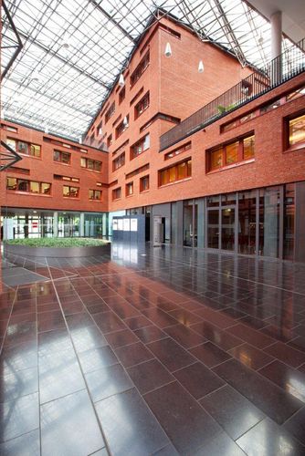 An atrium of a building complex surrounded by red-brick and glass walls