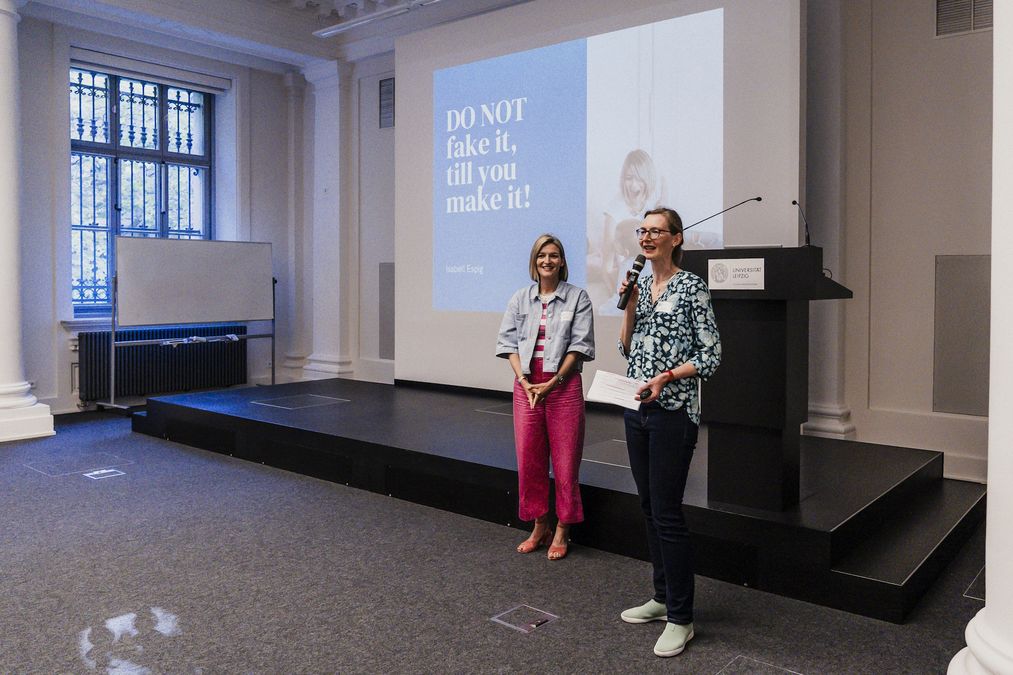 zur Vergrößerungsansicht des Bildes: Blick von rechts auf die Bühne, wo Susanne Benko aus dem Organisationsteam die Referentin Isabell Espig anmoderiert. Foto: Christin Hiebner