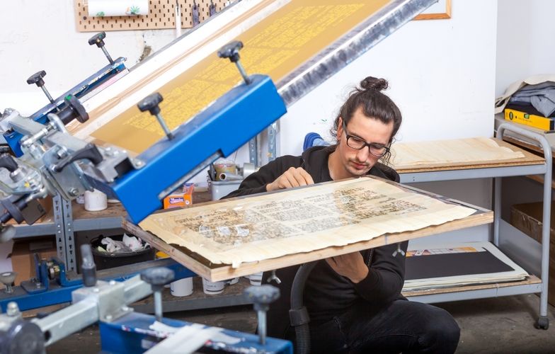 Dennis Blumenstein bei der aufwändigen Herstellung der Replik des Papyrus Ebers per Siebdruckverfahren in der Leipziger Werkstatt von Schmidt, Blumenstein GbR.