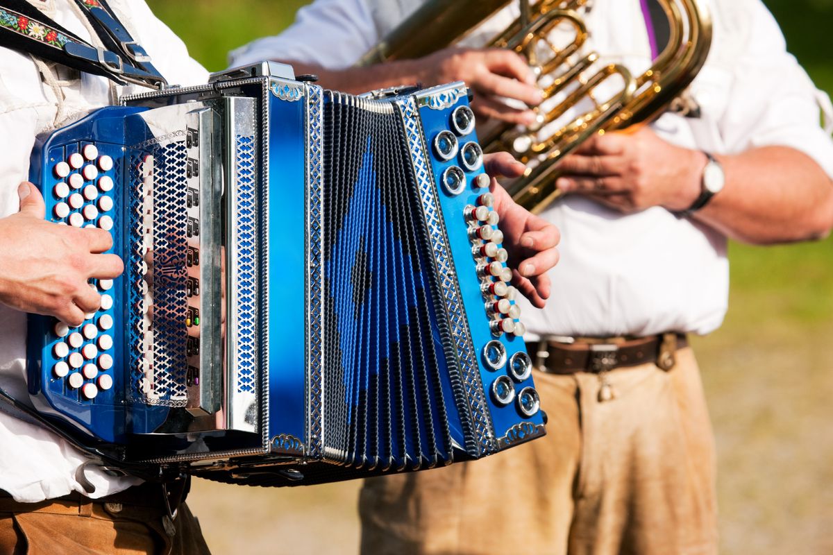 zur Vergrößerungsansicht des Bildes: Zu sehen sind zwei Mitgleider eines Musikvereins. Einer von ihnen spielt auf dem Akkordeon, der andere spielt Euphonium. 