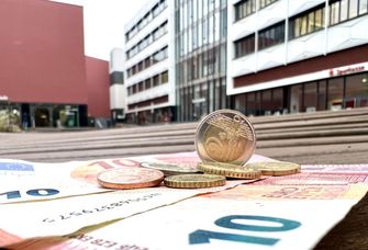 Münzen und Geldscheine auf einer Bank im Innenhof auf dem Campus Augustusplatz.