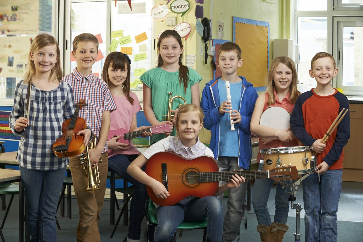 zur Vergrößerungsansicht des Bildes: Man sieht Kinder, die mit ihren Instrumenten posieren.