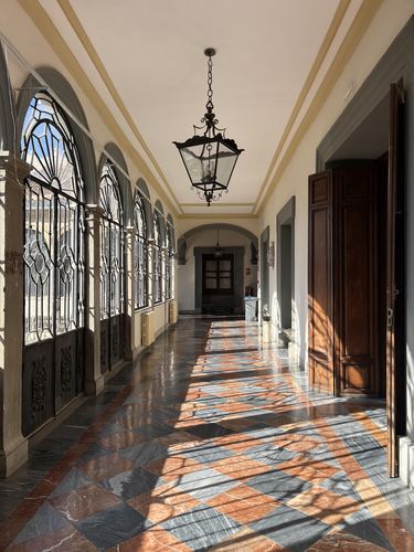 Blick in den elegant verzierten Flur der Fakultät, der gerade von Sonnenlicht durschienen wird.