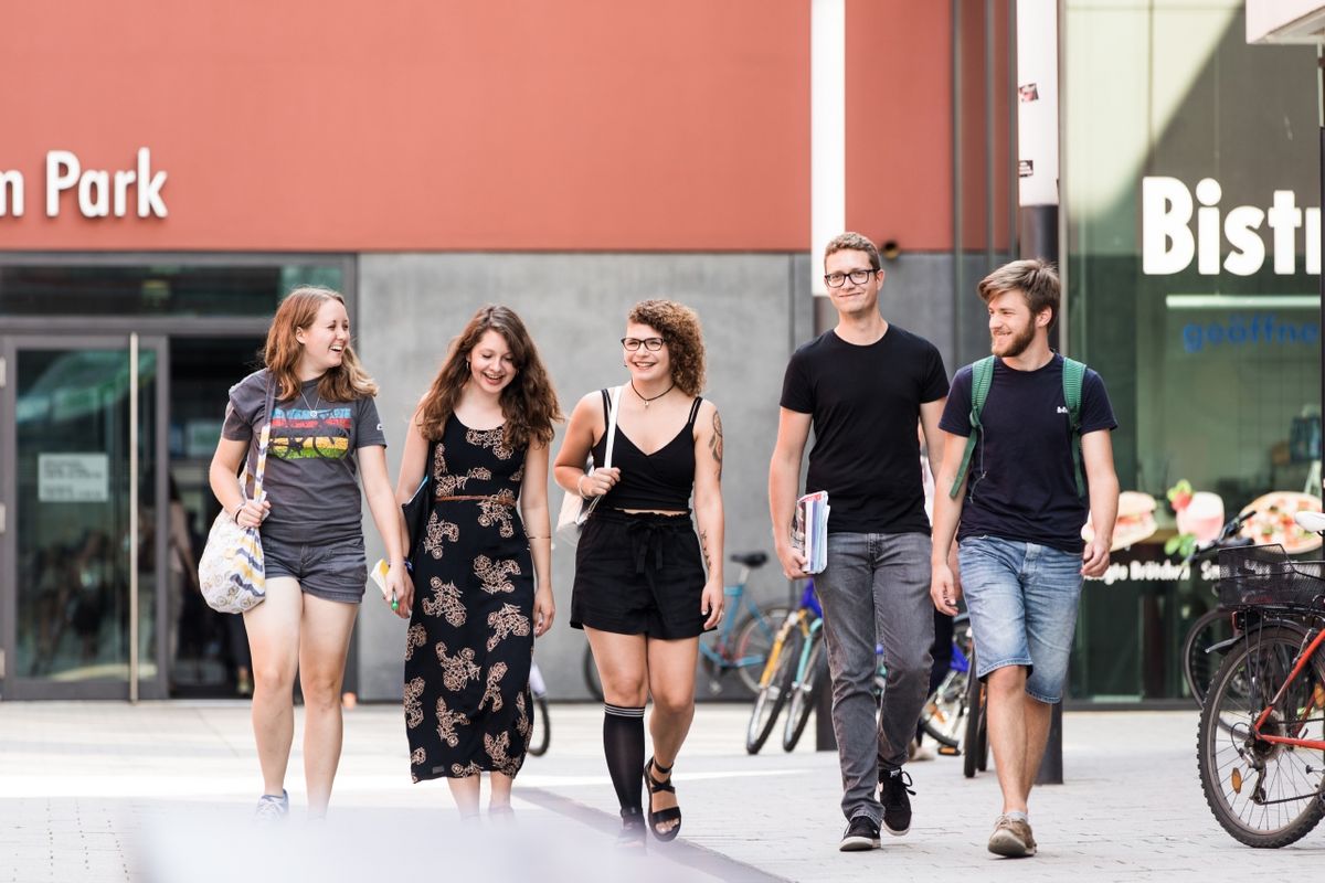 enlarge the image: Studierende gehen nebeneinander auf dem Campusgelände