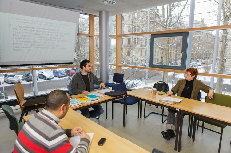 Lecturers and students sit together in the seminar