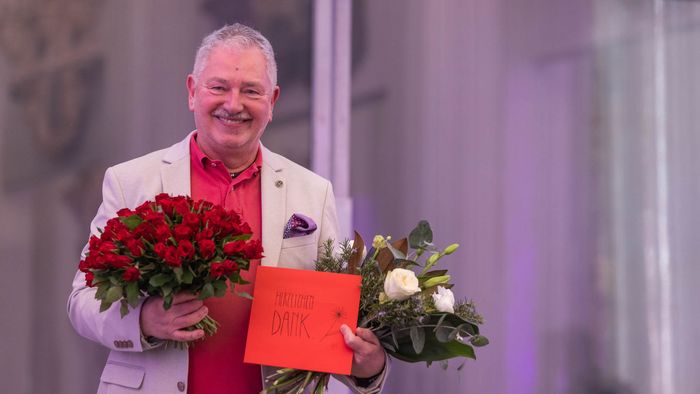 Herr Dr. Ronthaler, der die Letzte Vorlesung gehalten hat, mit zwei Blumensträußen. 
