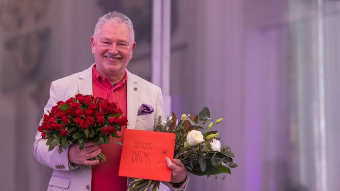 Jürgen Ronthaler, der die Letzte Vorlesung gehalten hat, mit zwei Blumensträußen. 