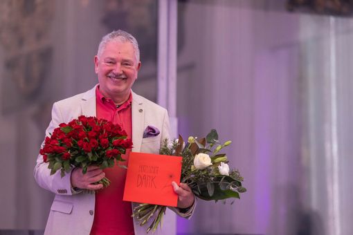 Herr Dr. Ronthaler, der die Letzte Vorlesung gehalten hat, mit zwei Blumensträußen. 