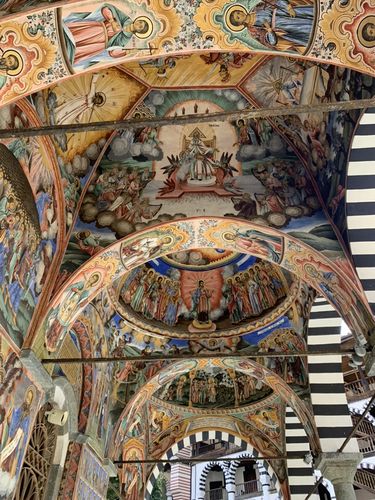 Zu sehen ist das aufwendig verzierte und bunt dekorierte Unterdach eines orthodoxen Klosters in Bulgarien.