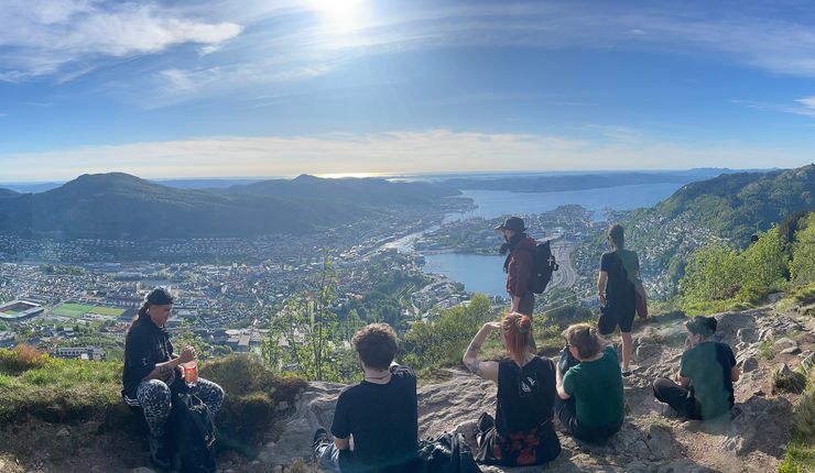 Several people photographed from behind on a mountain, enjoying the view