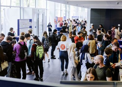500 Studieninteressierte aus aller Welt nutzten das Orientierungsangebot der Leipziger Hochschullandschaft. Foto: Anne Schwerin Auf dem Bild ist das Foyer der HTWK zu sehen, in dem sich sehr viele Menschen miteinander an Infoständen unterhalten und Infomaterialien lesen und ansehen.