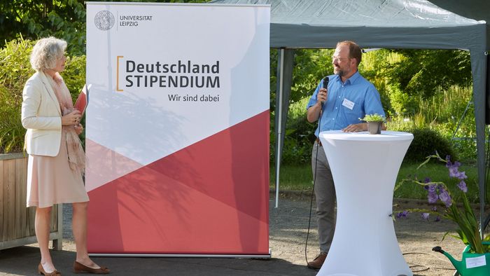Prof. Dr. Christian Wirth, Leiter des Botanischen Gartens hält Mikrofon in der Hand und begrüßt die Rektorin sowie die Gäste des Sommerfests.