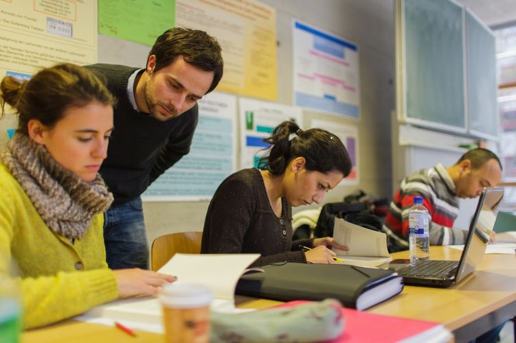 Students sit in the seminar and look at books