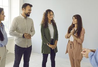 Runde von Kollegen steht zusammen, einer wird gelobt