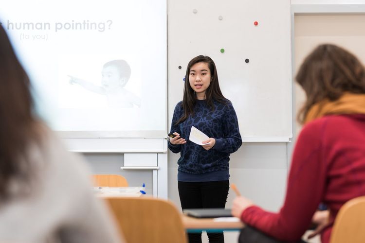 Man blickt nach vorne auf eine Studentin, die gerade etwas im Seminar vorträgt, Foto: Christian Hüller 