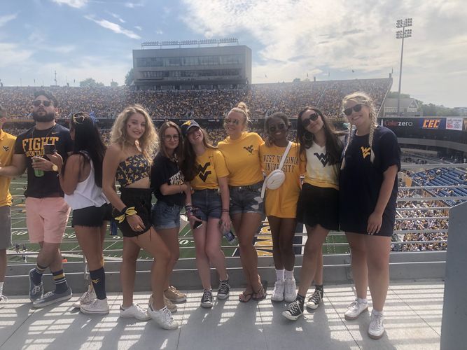 Hier sind internationalen Studentinnen in einem Footballstadion abgebildet.