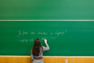 Studierende schreib auf Tafel