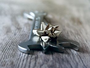 Auf einem Tisch liegen zwei Schraubenschlüssel mit einer silbernen Schleife.