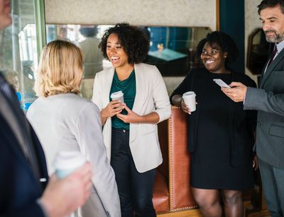 2 ladies chatting, being observed by a lady and a man with a phone