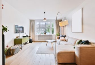 Wohnzimmer mit Sofa, Lampen, Tisch und Sideboard
