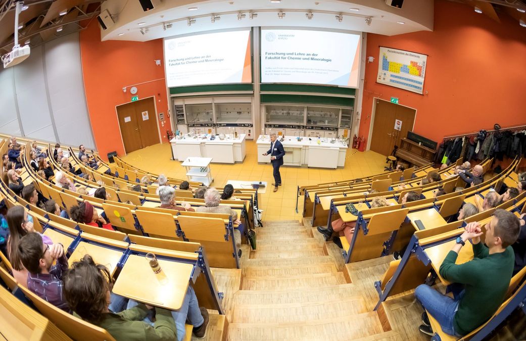 zur Vergrößerungsansicht des Bildes: Prodekan, Prof. Kohlmann, steht im Hörsall vor den Gästen und gibt Informationen zur Fakultät
