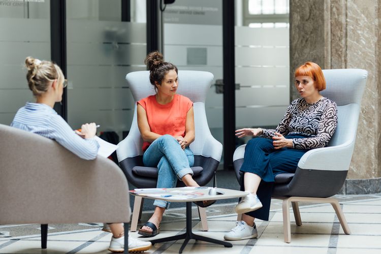 Zu sehen ist Lina Hörügel im Gespräch mit Helen Matthey und Jana Kuppardt.