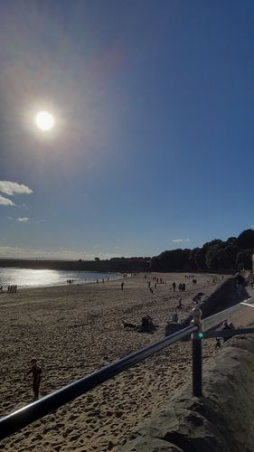 Blick auf den langgezogenen Strand bei Sonnenschein.