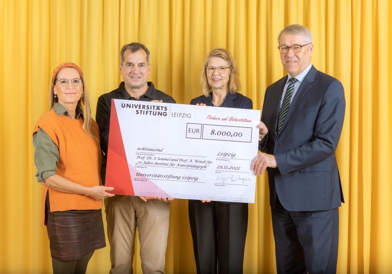 zur Vergrößerungsansicht des Bildes: Farbfoto: Prof. Dr. Birgit Dräger, Dr. Hubert Temmeyer und Prof. Dr. Harald Krautscheid von der Universitätsstiftung überreichen den symbolischen Scheck an die Fördermittelempfängerin Prof. Dr. Ines Seumel