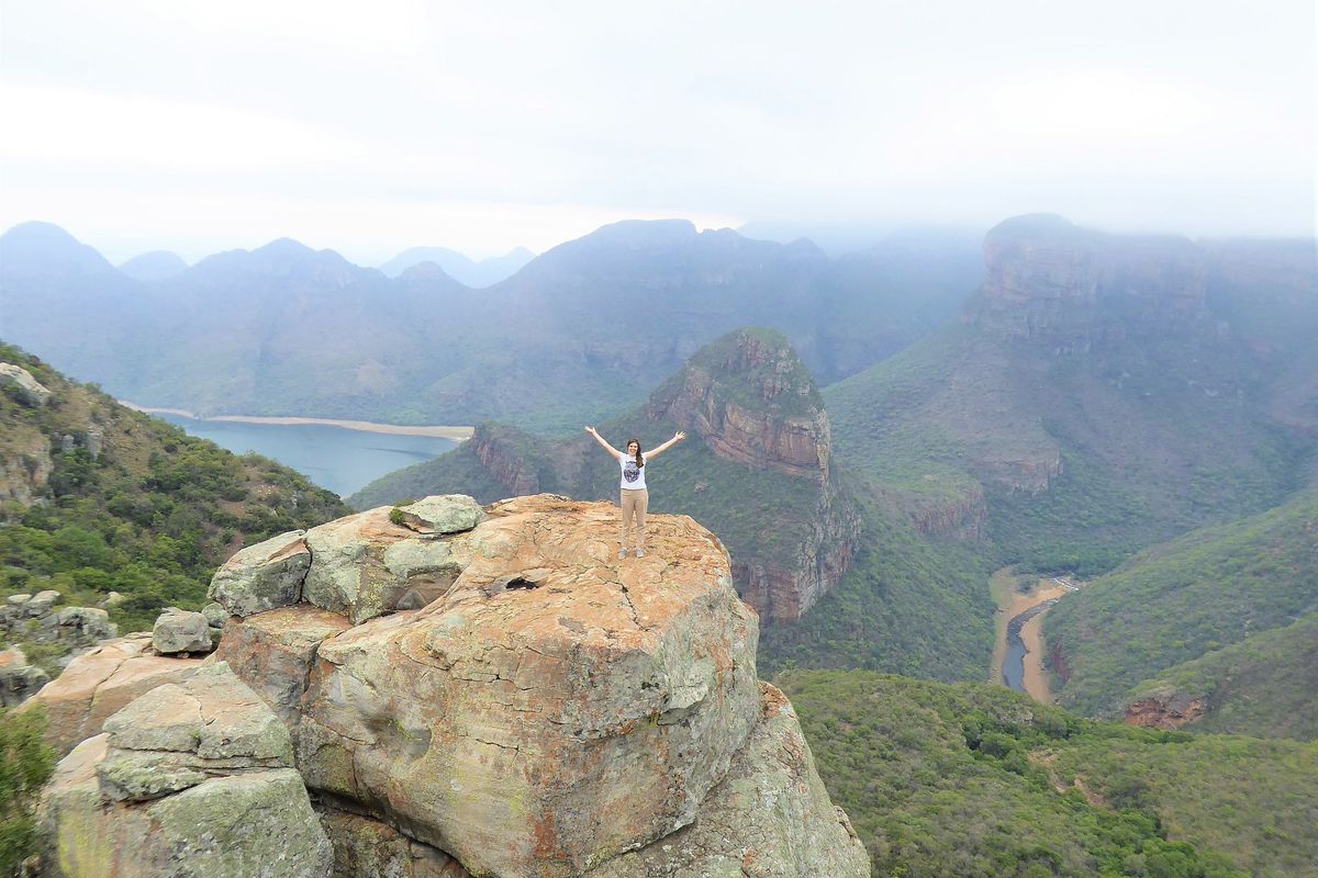 enlarge the image: Student Natascha stands on a high mountain in South Africa, photographed from a great distance, with Gebrige in the background.