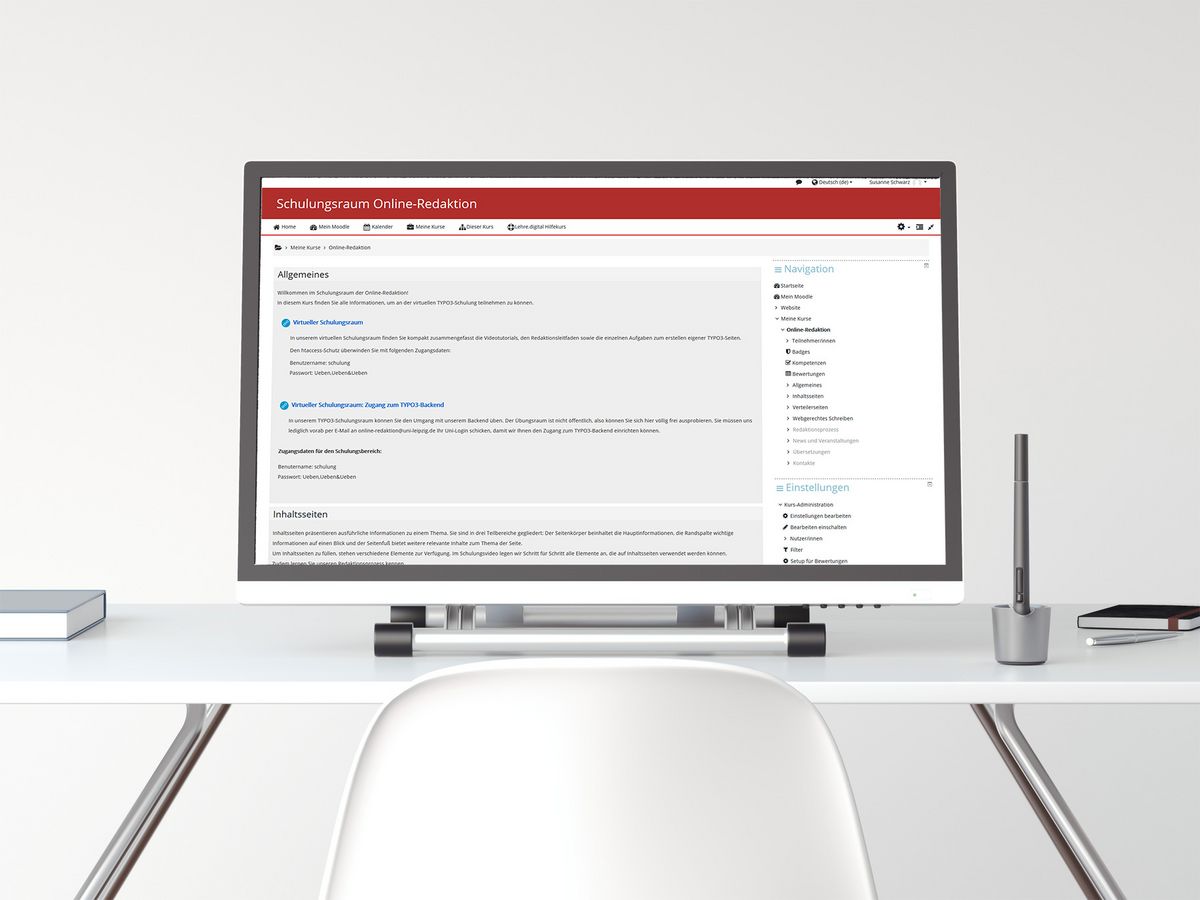 zur Vergrößerungsansicht des Bildes: Auf einem Schreibtisch steht ein großer Computerbildschirm, der den Moodle-Kurs der Online-Redaktion anzeigt. anzeigt. 