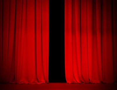 Zu sehen ist ein roter Theatervorhang.