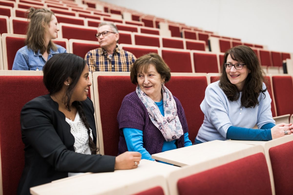 zur Vergrößerungsansicht des Bildes: Fünf Alumni unterhalten sich im Audimax