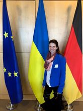 Solveig Richter vor der deutschen, der europäischen und der ukrainischen Flagge,