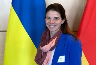 Solveig Richter vor der deutschen, der europäischen und der ukrainischen Flagge,