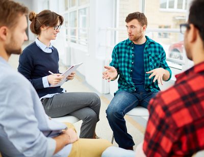 Zu sehen ist eine Gruppe junger Menschen, die in eine Diskussion vertieft sind.