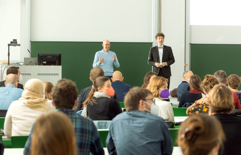 Two professors speaking in front of the audience 