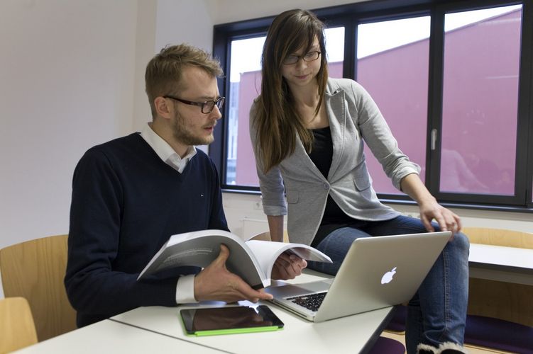 Ein Student und eine Studentin sitzen beisammen und reden über eine Aufgabe, Foto: Christian Hüller 