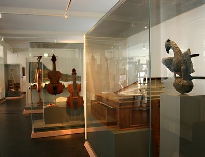 Verschiedene historische Streich- und Tasteninstrumente stehen in dem gezeigten Ausstellungsraum.