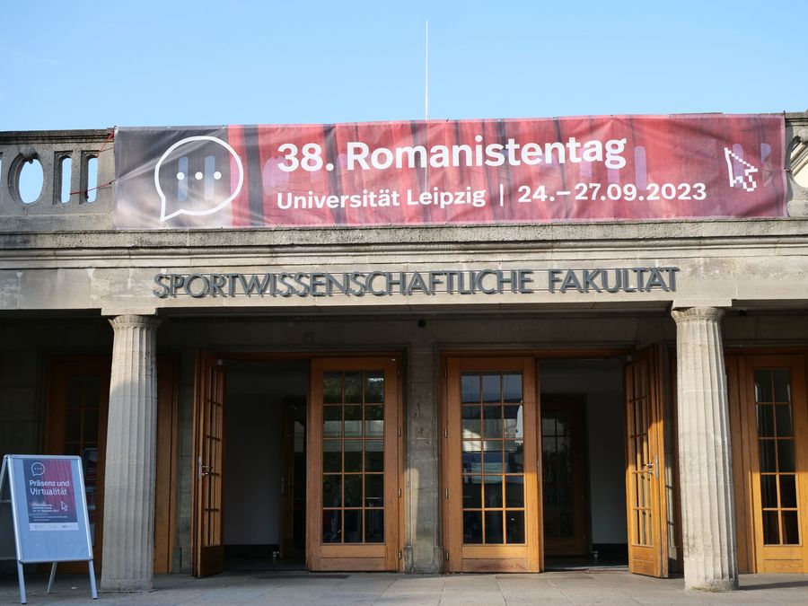 zur Vergrößerungsansicht des Bildes: Banner des 38. Romanistentags über dem Eingang der Sportwissenschaftlichen Fakultät