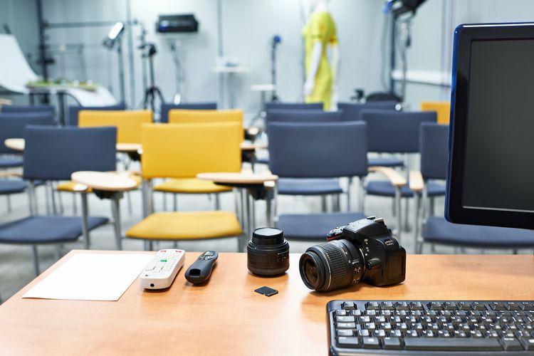 Leerer Raum mit vielen Stühlen, vorn steht ein Tisch mit Equipment zur Aufzeichnung von Veranstaltungen.