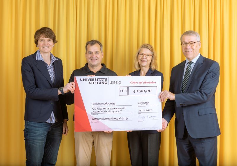 zur Vergrößerungsansicht des Bildes: Farbfoto: Prof. Dr. Birgit Dräger, Dr. Hubert Temmeyer und Prof. Dr. Harald Krautscheid von der Universitätsstiftung überreichen den symbolischen Scheck an die Fördermittelempfängerin Jun.-Prof. Dr. Anna Stemmann