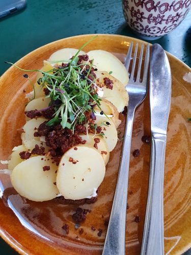 Ein belegtes Brot auf einem gelben Teller in einem Café.