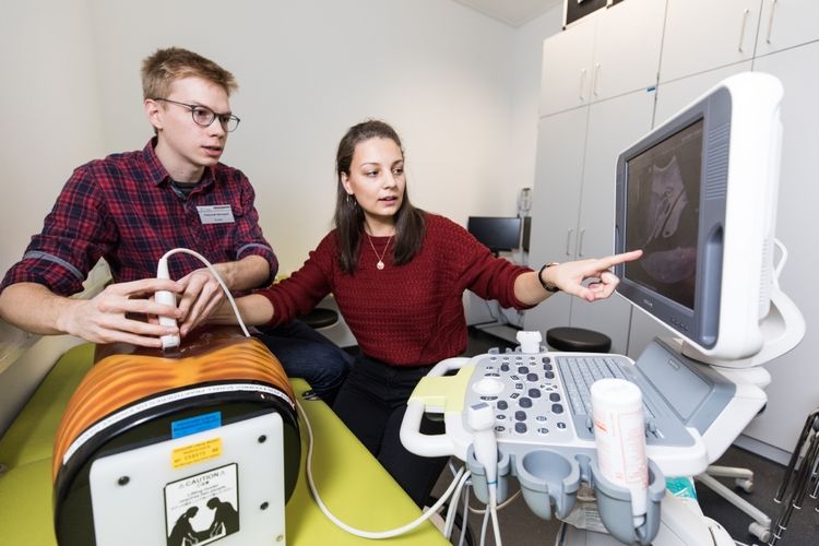 Tutor Conrad leitet Studentin Julia bei einer Ultraschalluntersuchung an