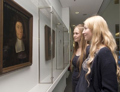 Zwei junge Frauen betrachten ein Portrait der Professorengalerie der Kustodie Leipzig.