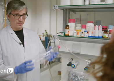 Dr. Christian Sonnendecker stellt in der Dokumentation ein neues Verfahren zum PET-Recycling vor, Foto: ZDF Mediathek / Screenshot Dr. Christian Sonnendecker im Interview in einem Labor mit einer PET-Flasche in der Hand