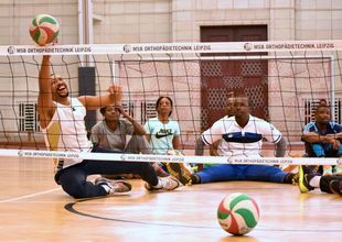 Eine Sitzvolleyball-Mannschaft beim Spiel.